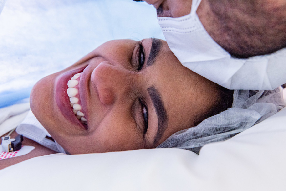 O beijo na testa da mãe dado pelo pai depois do parto bem sucedido do bebê Gustavo que nasceu na Maternidade Perinatal da Barra da Tijuca. Imagens da fotógrafa de casamento e famílias Jaque Salles 