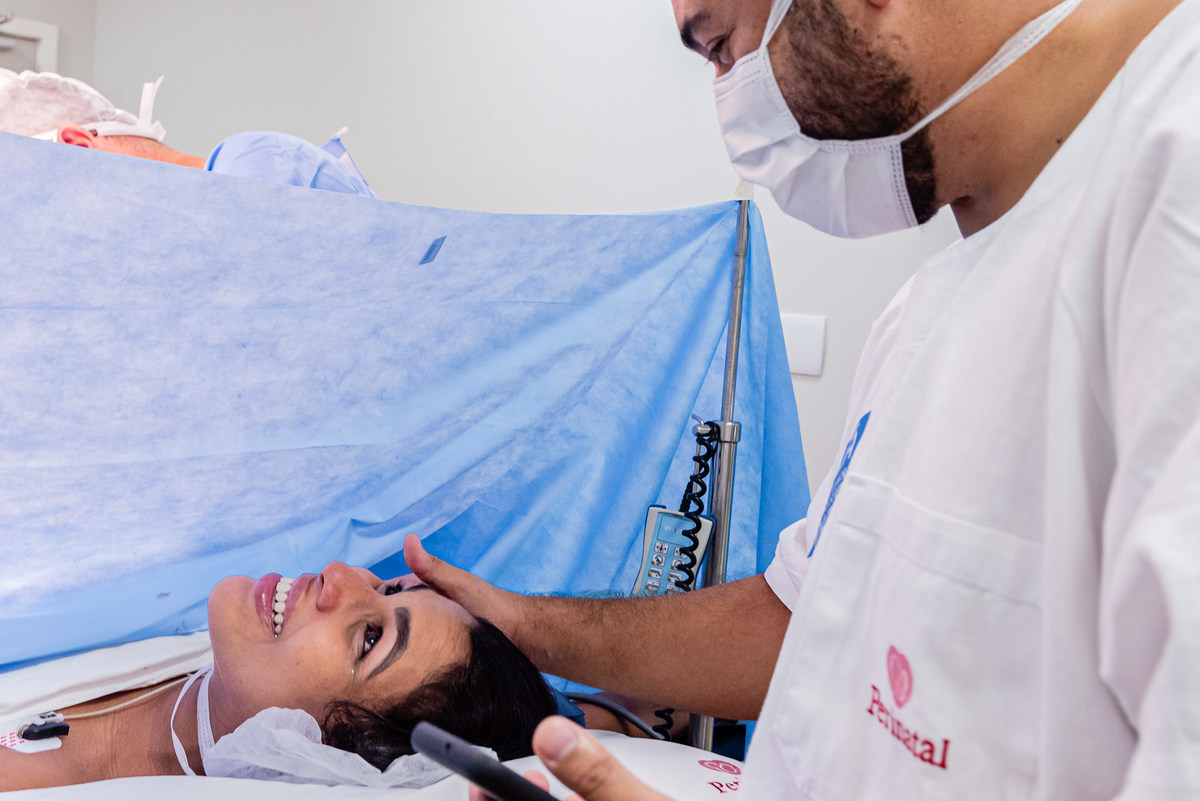 O carinho recebido pela mãe depois de dar a luz ao segundo filho do casal. Parto realizado na Maternidade Perinatal da Barra da Tijuca. Imagens da fotógrafa de casamento e famílias Jaque Salles 