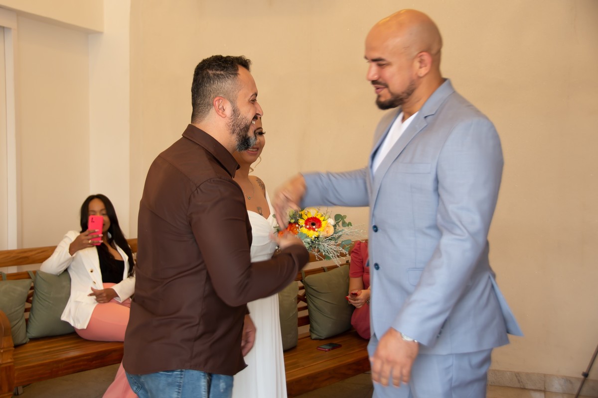 A noiva fez a entrada com o seu irmaos na sala de casamentos do cartório Colorado