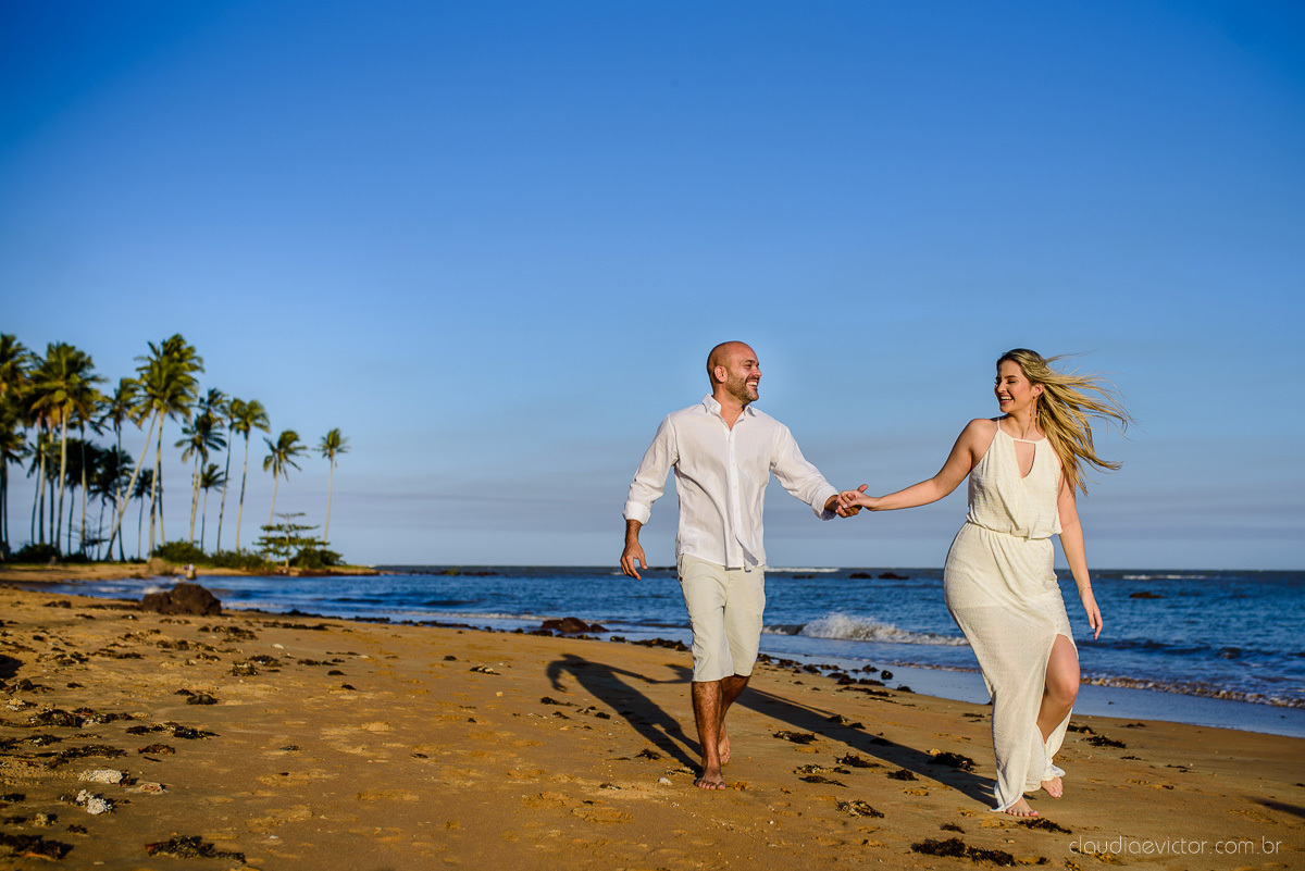 Lindo ensaio casal pre wedding com noivo e noiva na praia de coqueiral de aracruz feito por fotógrafos de casamento de vila velha fotógrafos de casamento de vitória fotógrafos de casamento de serra espirito santo es com praia, por do sol e guarda chuva
