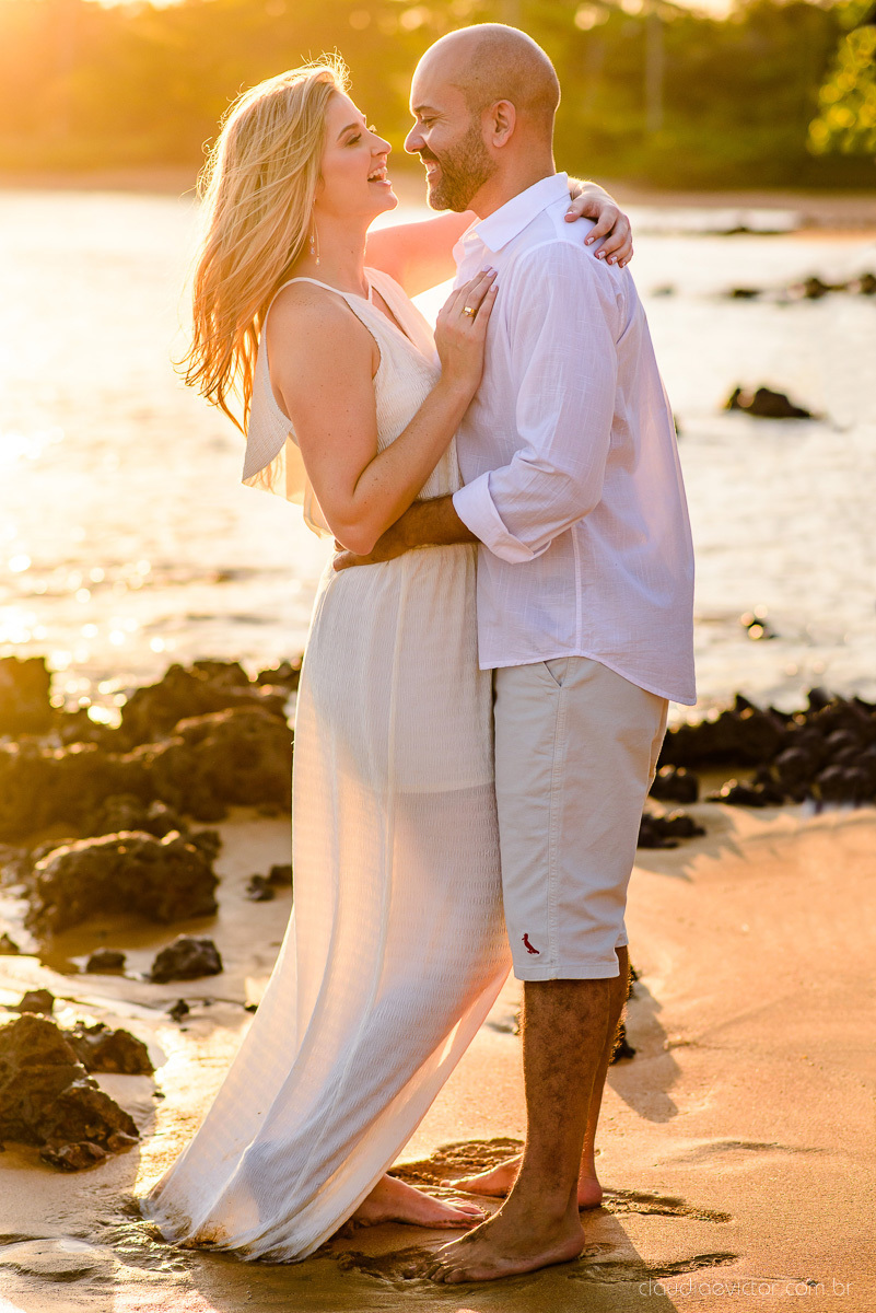 Lindo ensaio casal pre wedding com noivo e noiva na praia de coqueiral de aracruz feito por fotógrafos de casamento de vila velha fotógrafos de casamento de vitória fotógrafos de casamento de serra espirito santo es com praia, por do sol e guarda chuva