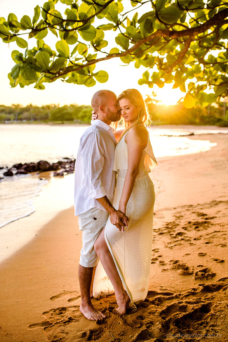 Lindo ensaio casal pre wedding com noivo e noiva na praia de coqueiral de aracruz feito por fotógrafos de casamento de vila velha fotógrafos de casamento de vitória fotógrafos de casamento de serra espirito santo es com praia, por do sol e guarda chuva