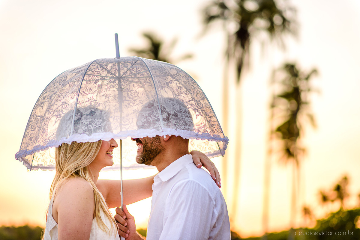 Lindo ensaio casal pre wedding com noivo e noiva na praia de coqueiral de aracruz feito por fotógrafos de casamento de vila velha fotógrafos de casamento de vitória fotógrafos de casamento de serra espirito santo es com praia, por do sol e guarda chuva