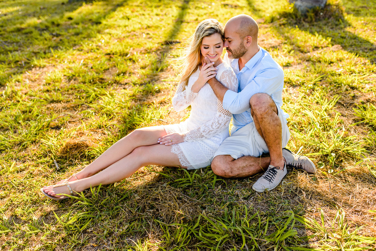 Lindo ensaio casal pre wedding com noivo e noiva na praia de coqueiral de aracruz feito por fotógrafos de casamento de vila velha fotógrafos de casamento de vitória fotógrafos de casamento de serra espirito santo es com praia, por do sol e guarda chuva