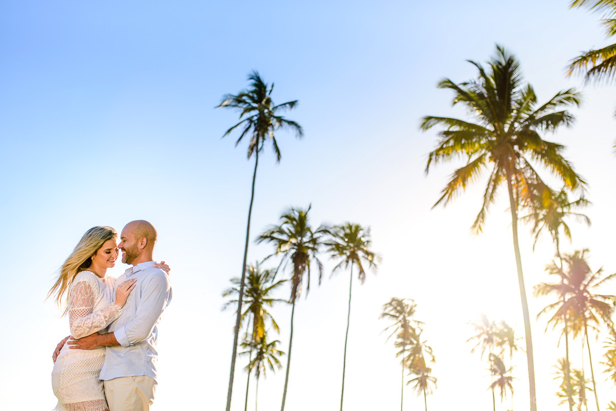 Lindo ensaio casal pre wedding com noivo e noiva na praia de coqueiral de aracruz feito por fotógrafos de casamento de vila velha fotógrafos de casamento de vitória fotógrafos de casamento de serra espirito santo es com praia, por do sol e guarda chuva