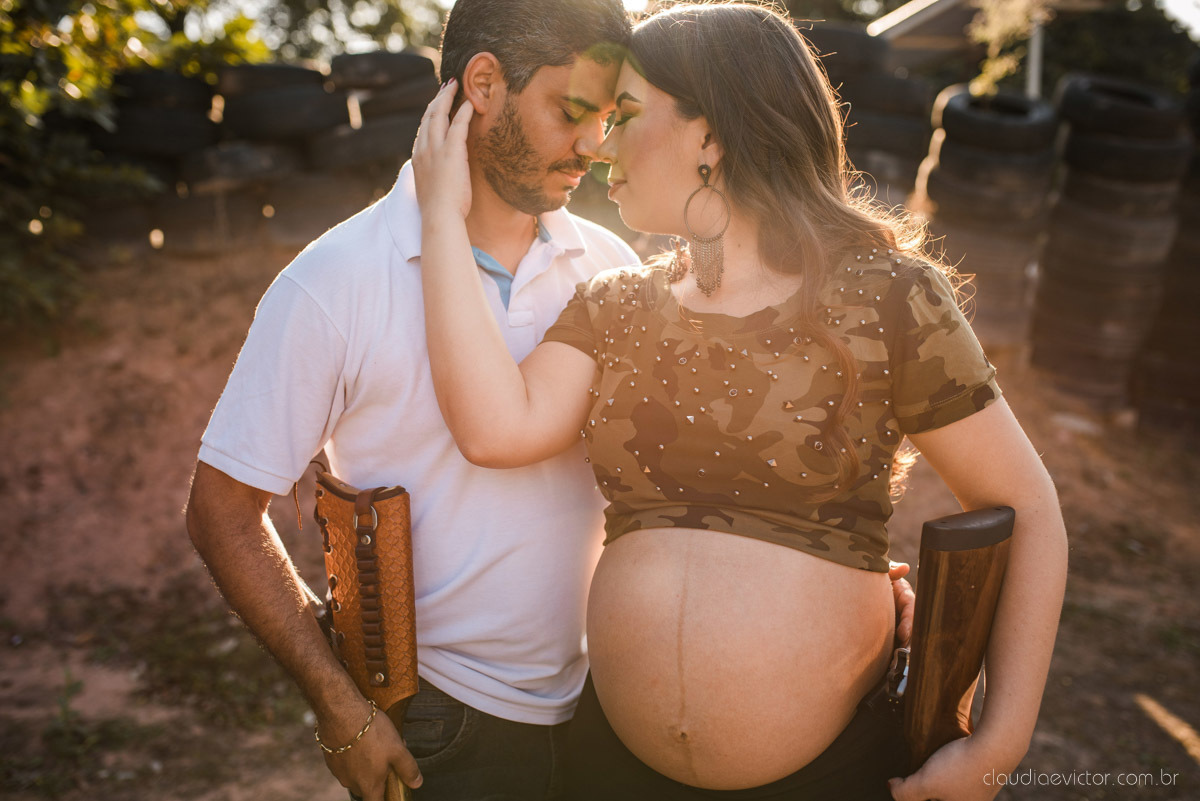 Lindo ensaio de gestante e família feito na praia e no clube de tiro com coleção de armas feito por fotógrafo de casamento em vila velha fotógrafo de casamento em vitória fotógrafo de casamento em serra com pôr do sol e violão