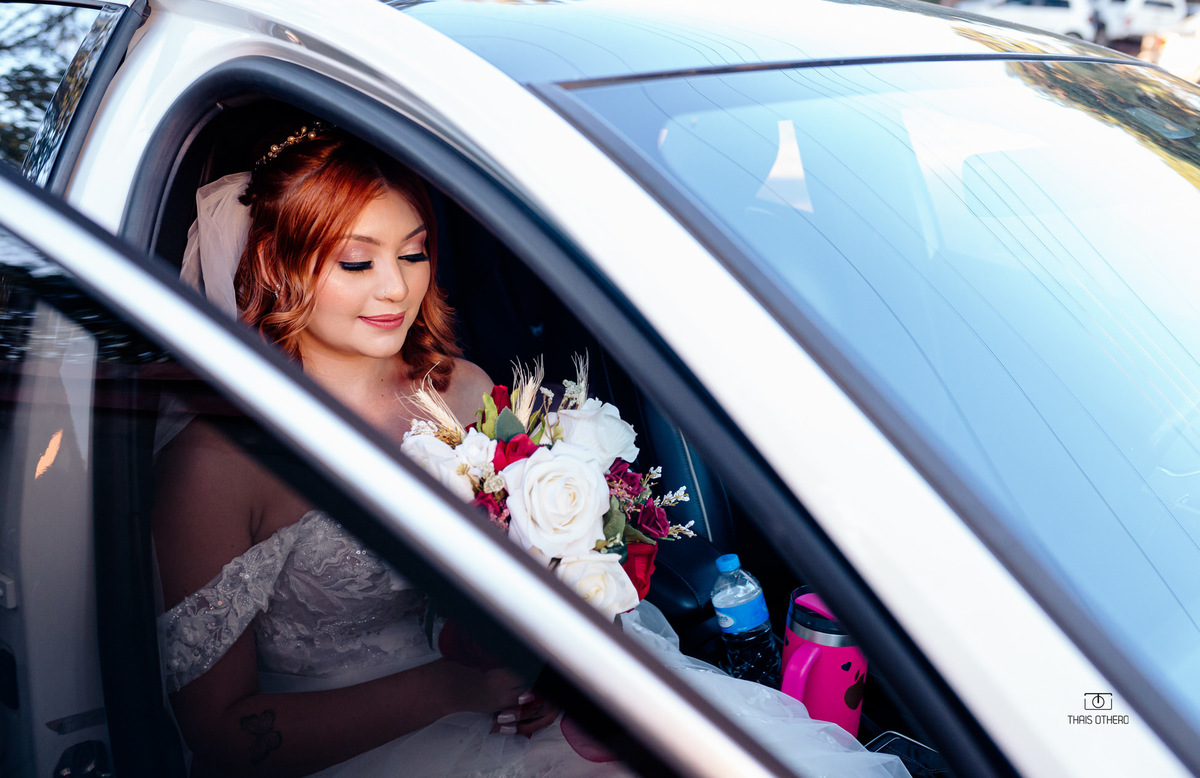 Noiva com bouquet de flores no carro