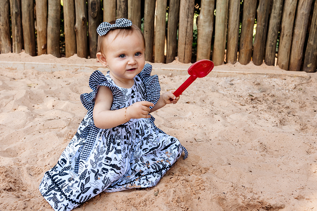 catarina brincando na areia com a pa