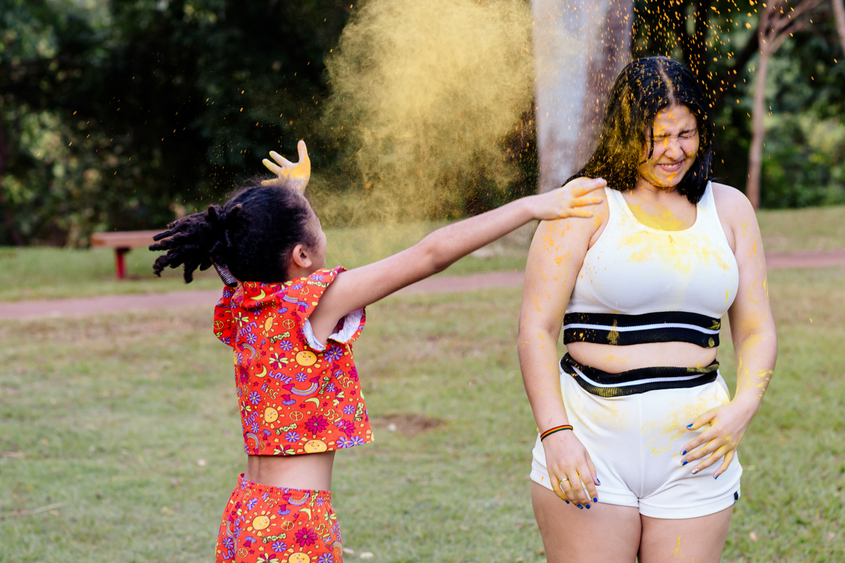 irma jogando po colorido na aniversariante