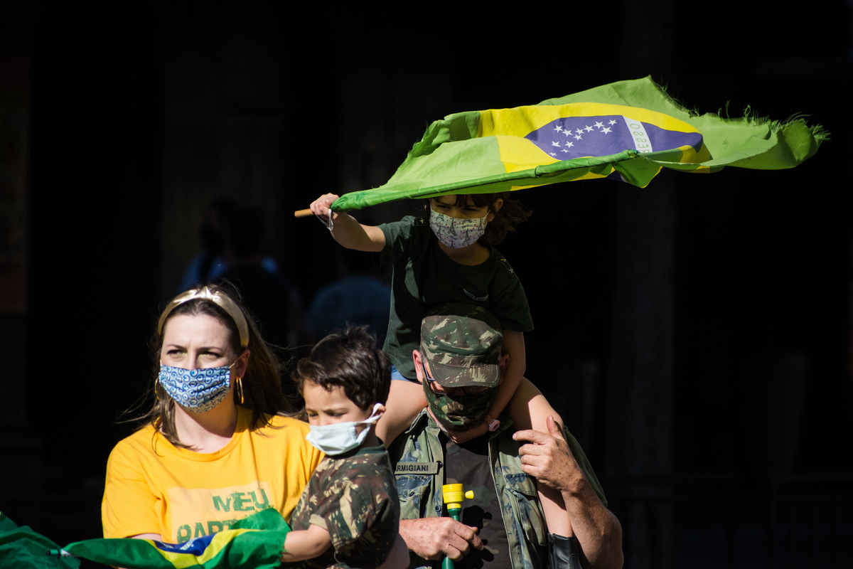 Famila com bandeira do Brasil e roupa camuflada chega  para protesto na Av Paulista