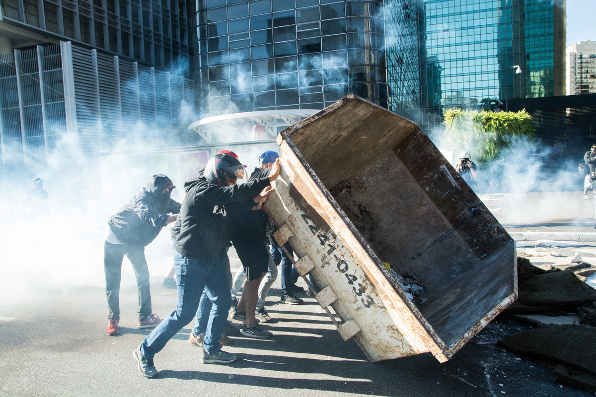 Manifestantes carregam caçamba de entulho para o meio da Av Paulista, para inibir o avanço da Policia militar na Av Paulista em 2020