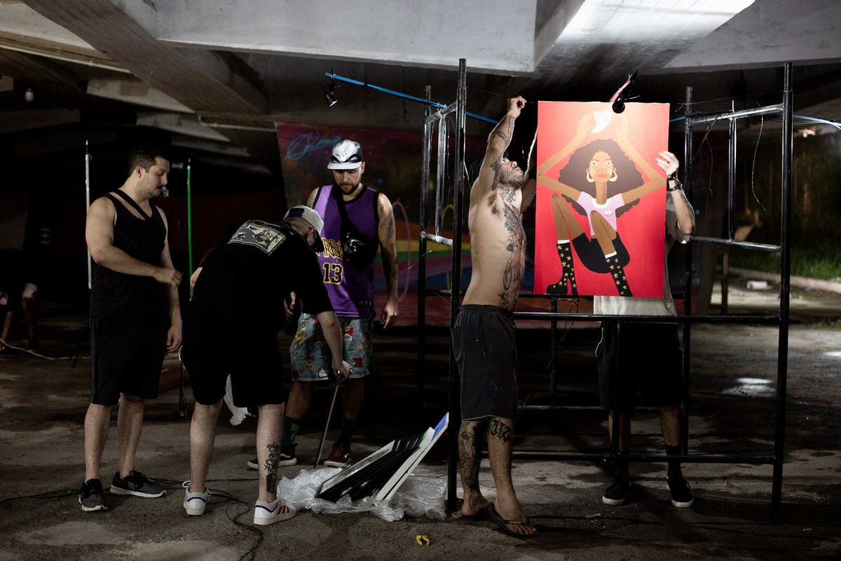 homens-arrumando-os-quadros