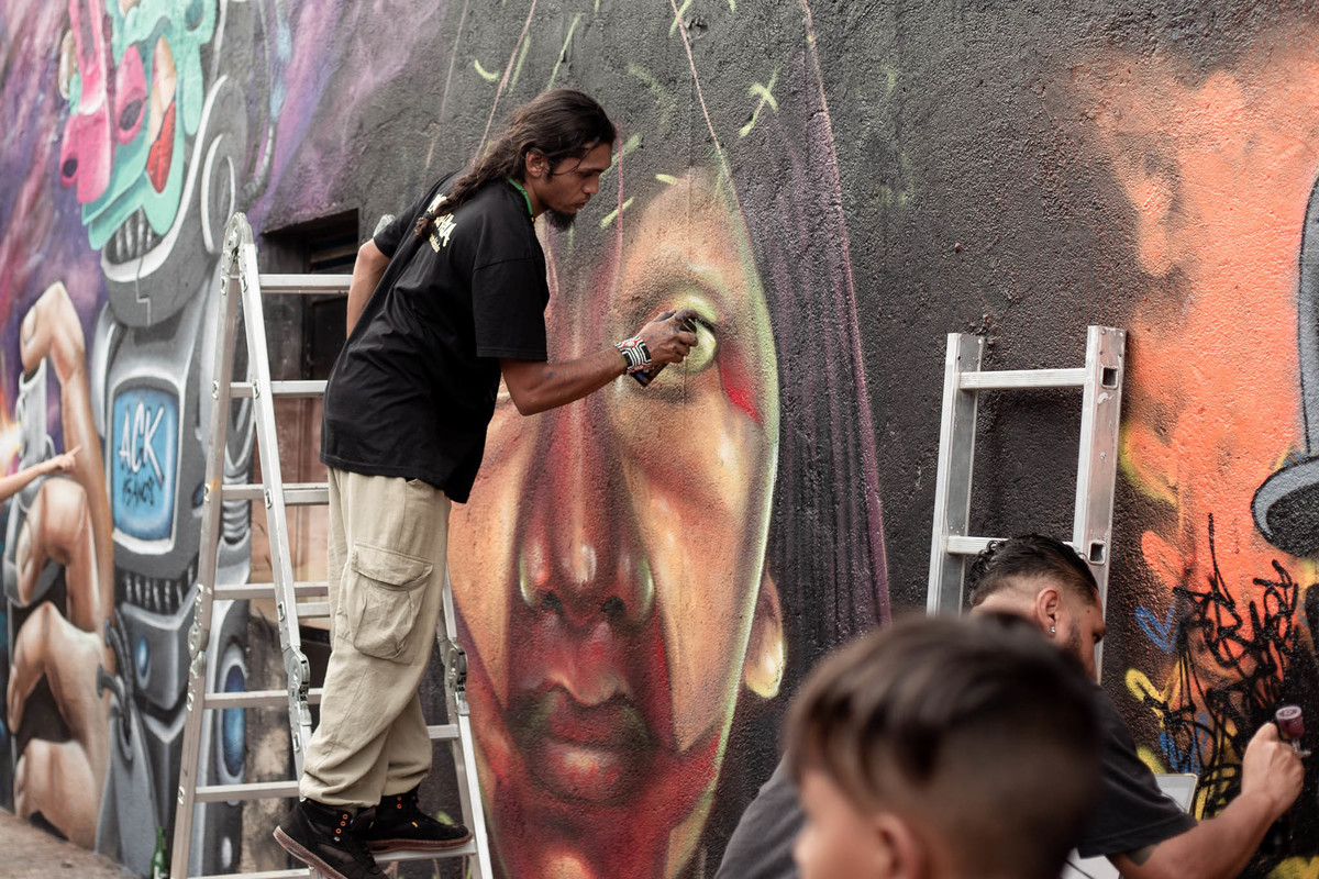 homem-pintando-rosto-no-muro