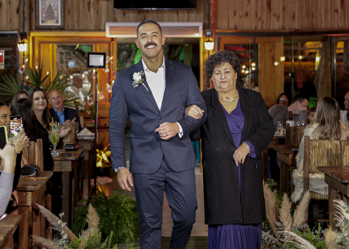 Hector entrando com sua mãe na locação do casamento.