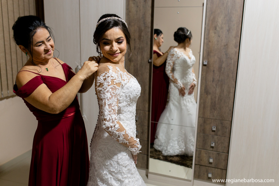 mae fechando o vestido da noiva