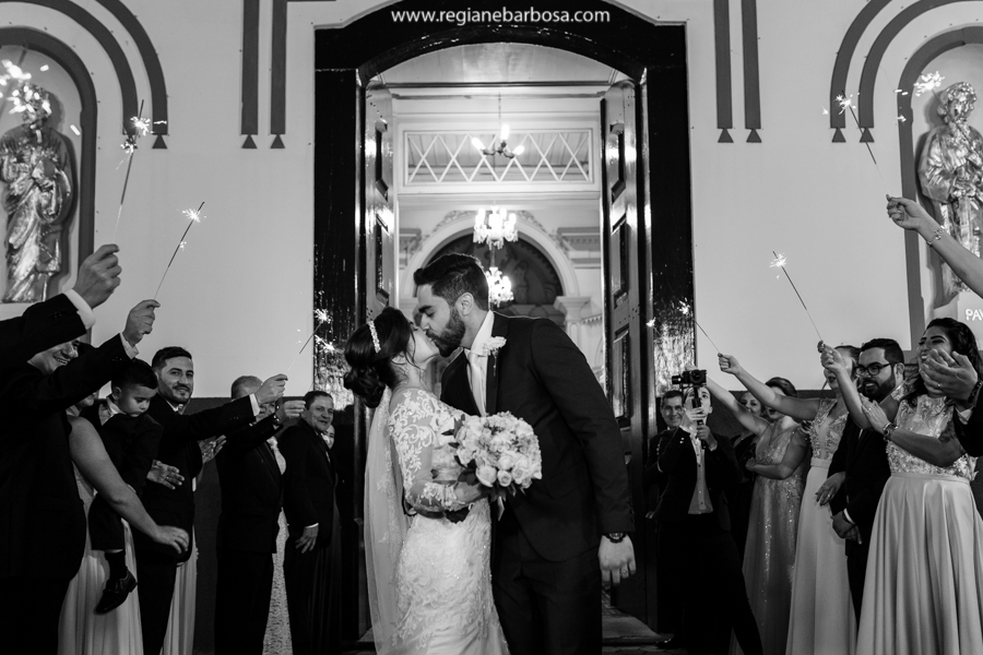 noivos beijando na porta da igreja