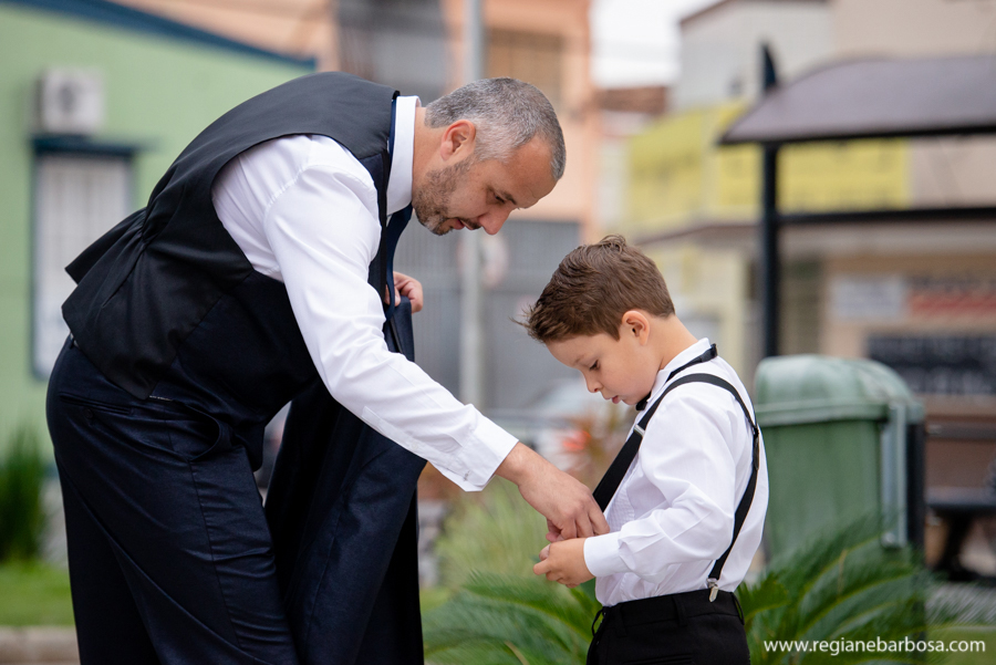 Noivo arrumando suspensorio do pajem