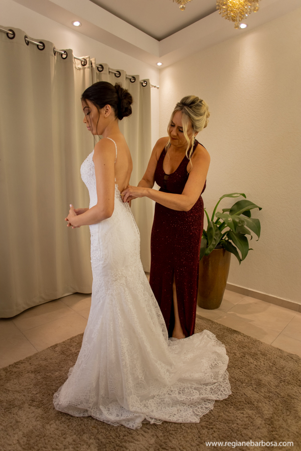 mae fechando o vestido da noiva