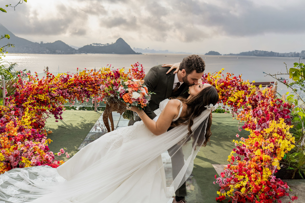 noivo-beijando-noiva-arco-floral-casamento.jpg