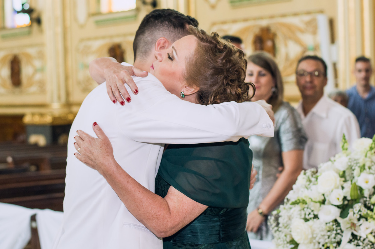Fotografia espontânea do noivo abraçando sua mãe