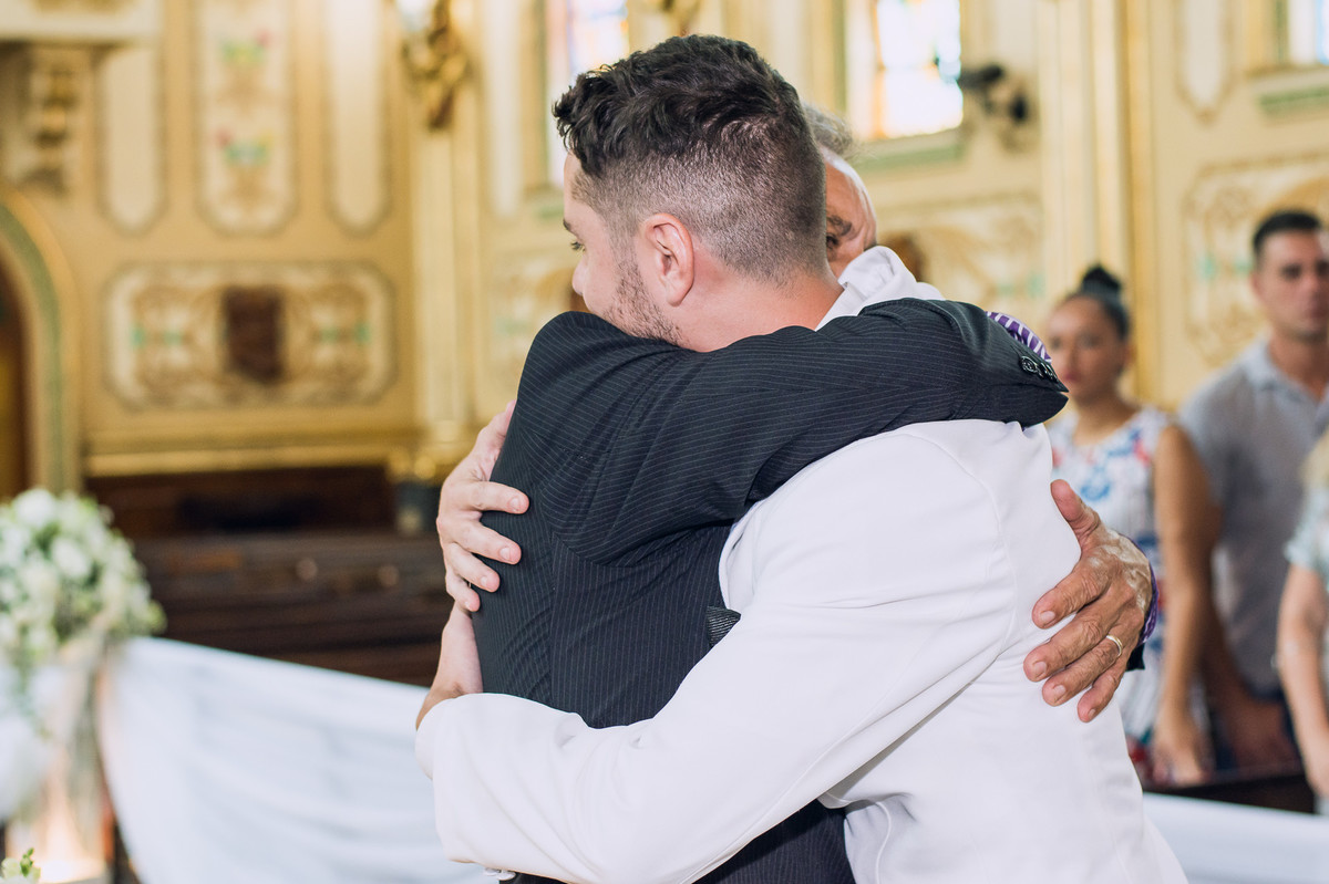Fotografia espontânea do noivo abraçando seu pai