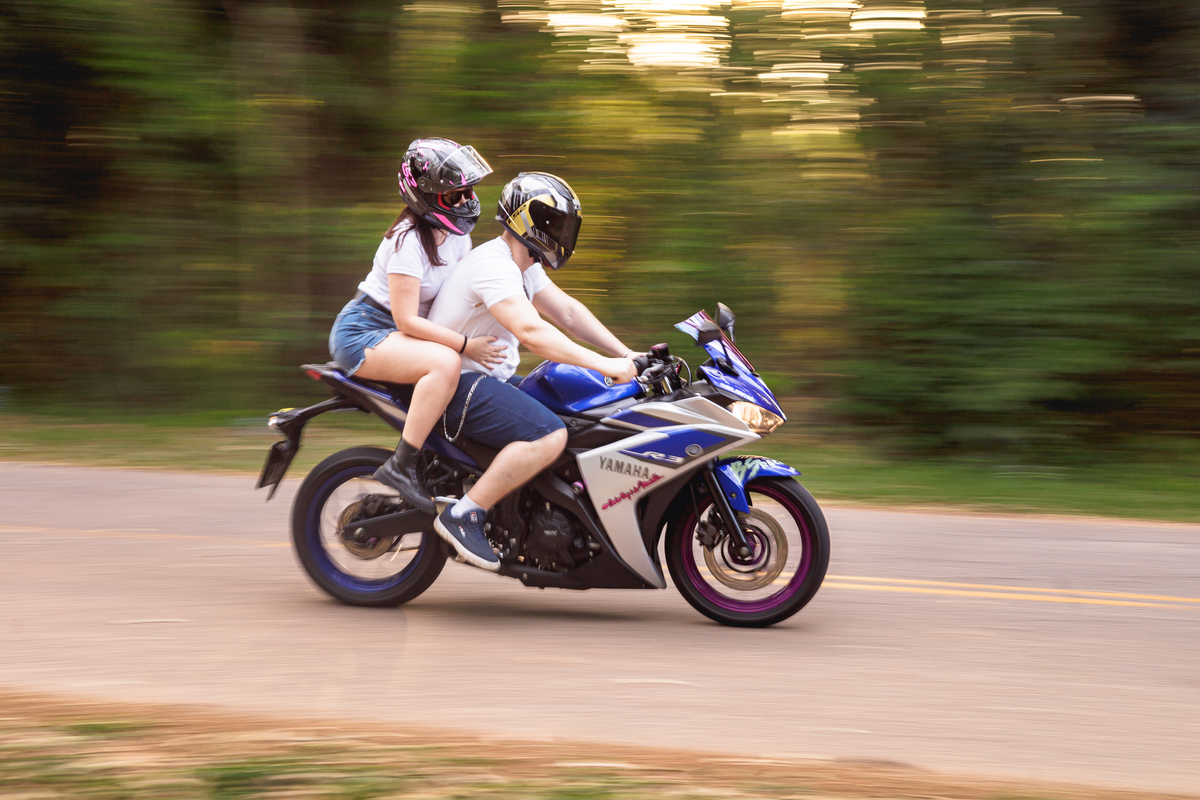 Ensaio pré-wedding realizado ao ar livre na serra do Japi em uma tarde ensolarada em Jundiaí com direito a fotos no pôr do sol. Imagem de um ensaio com um casal de motociclista e uma moto esportiva de alta velocidade. Fotografo de casamento.