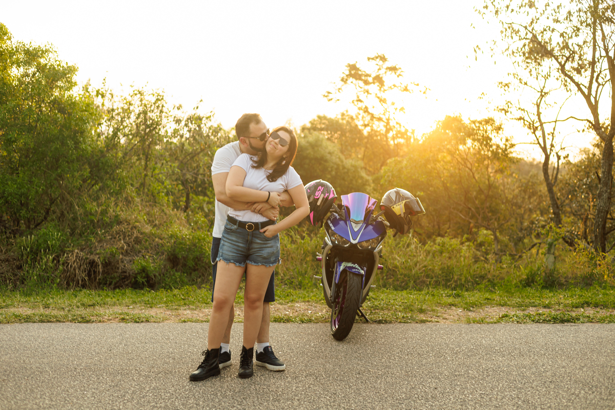 Ensaio pré-wedding realizado ao ar livre na serra do Japi em uma tarde ensolarada em Jundiaí com direito a fotos no pôr do sol. Imagem de um ensaio com um casal de motociclista e uma moto esportiva de alta velocidade. Fotografo de casamento.