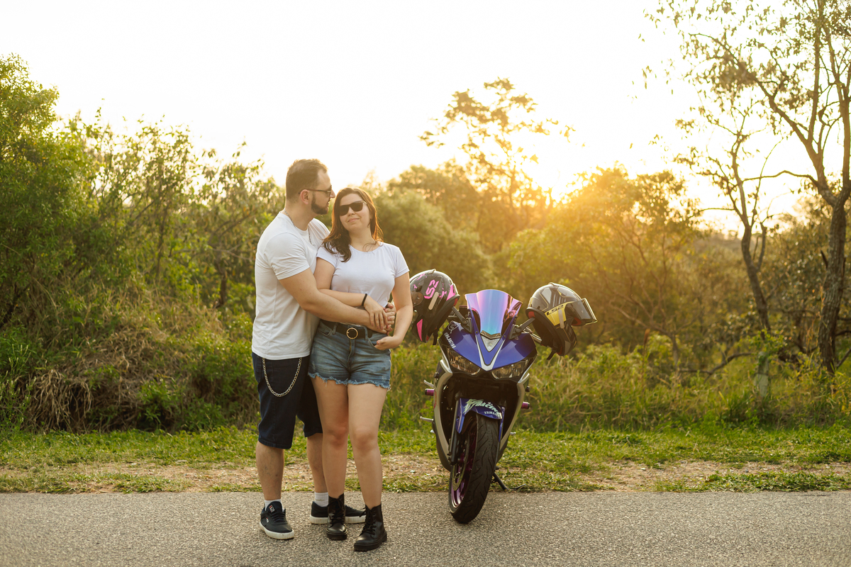 Ensaio pré-wedding realizado ao ar livre na serra do Japi em uma tarde ensolarada em Jundiaí com direito a fotos no pôr do sol. Imagem de um ensaio com um casal de motociclista e uma moto esportiva de alta velocidade. Fotografo de casamento.