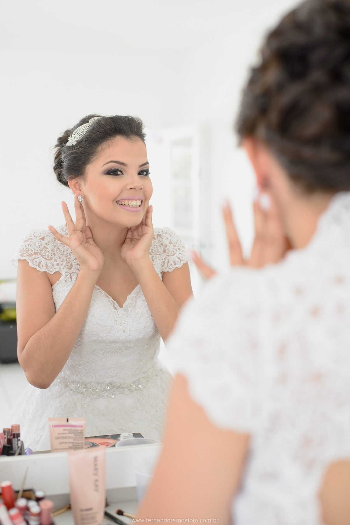 FOTO DE NOIVA COLOCANDO O BRINCO DURANTE MAKING OF NO SALÃO DE BELEZA CAROL FRANÇA AMKE UP