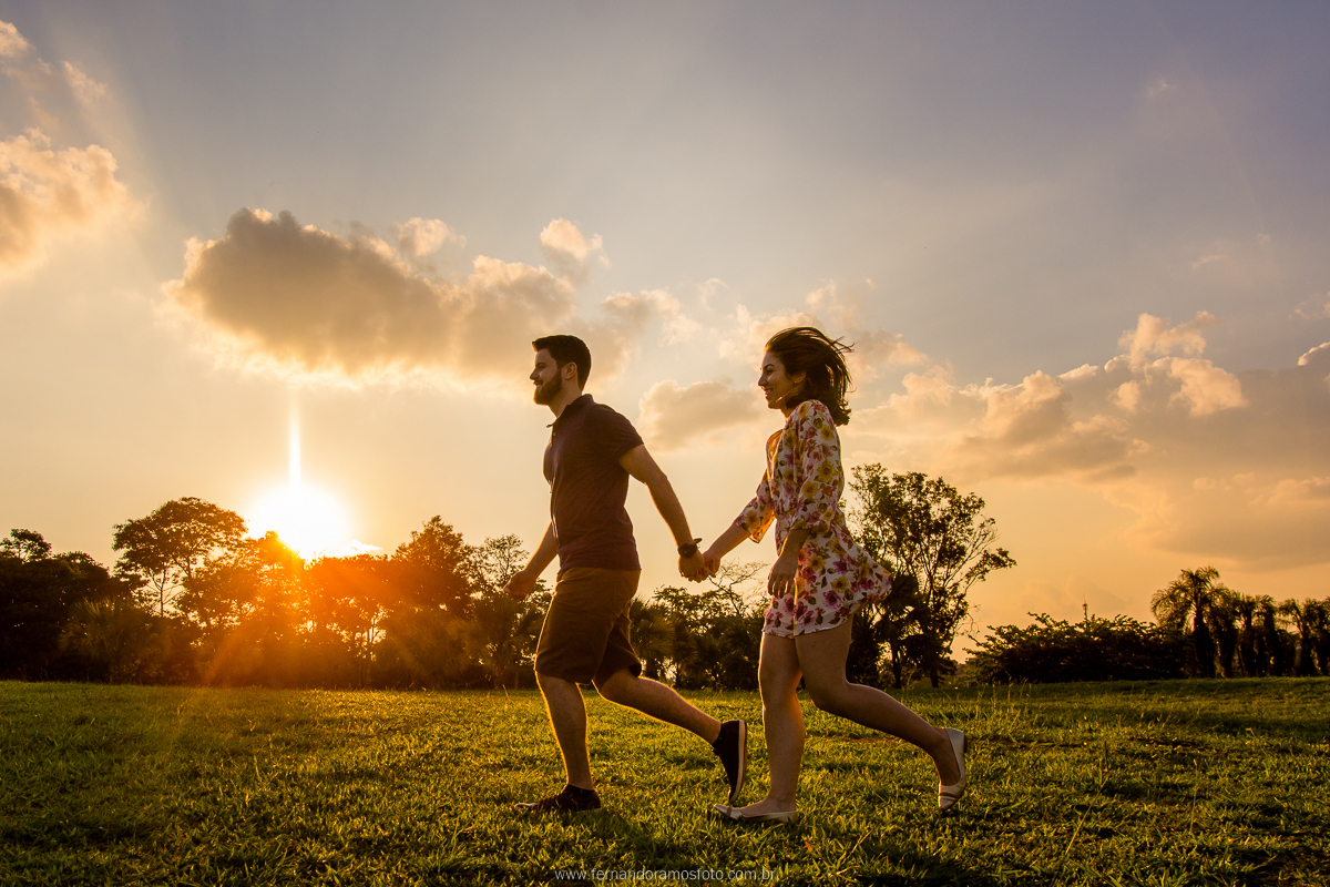 CASAL CORRENDO DURANTE ENSAIO PRE-CASAMENTO AO POR DO SOL NO PARQUE ECOLOGICO DE CAMPINAS - SP