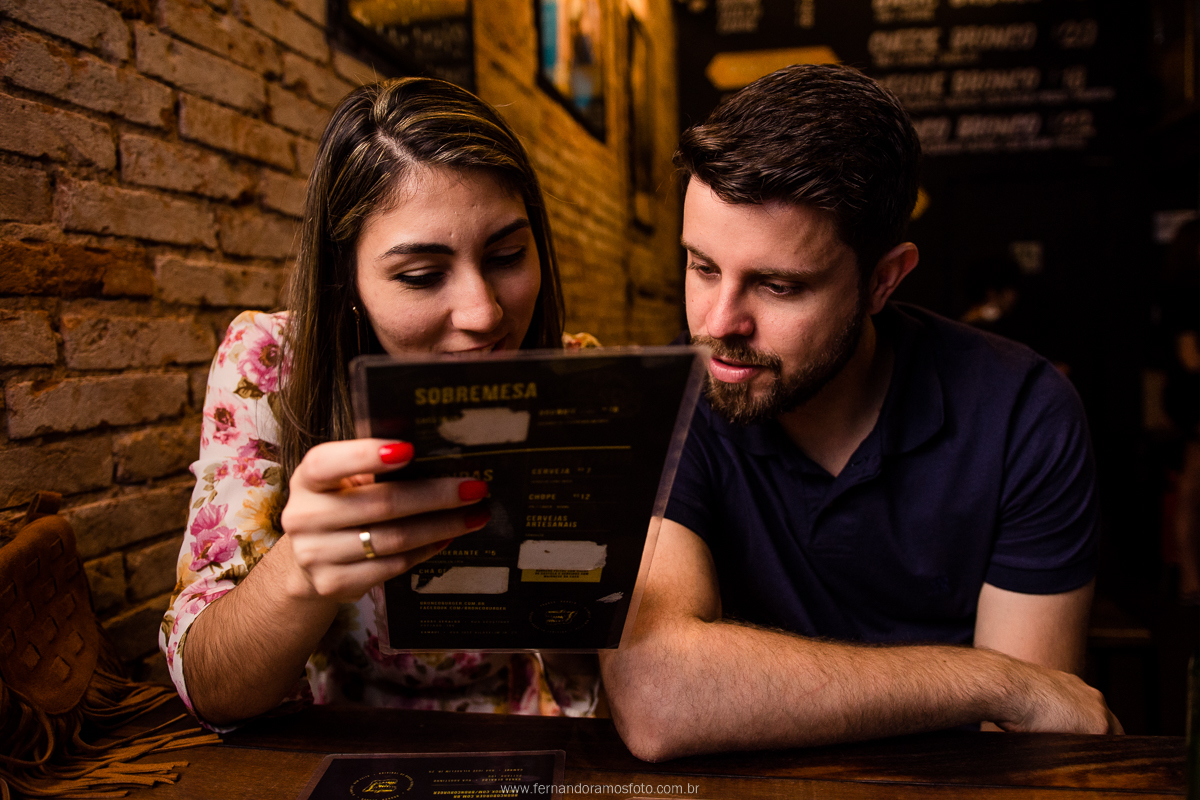 CASAL OLHANDO MENU DE LANCHES DA HAMBURGUERIA BRONCO BURGUER APOS ENSAIO PRE-CASAMENTO EM CAMPINAS - SP