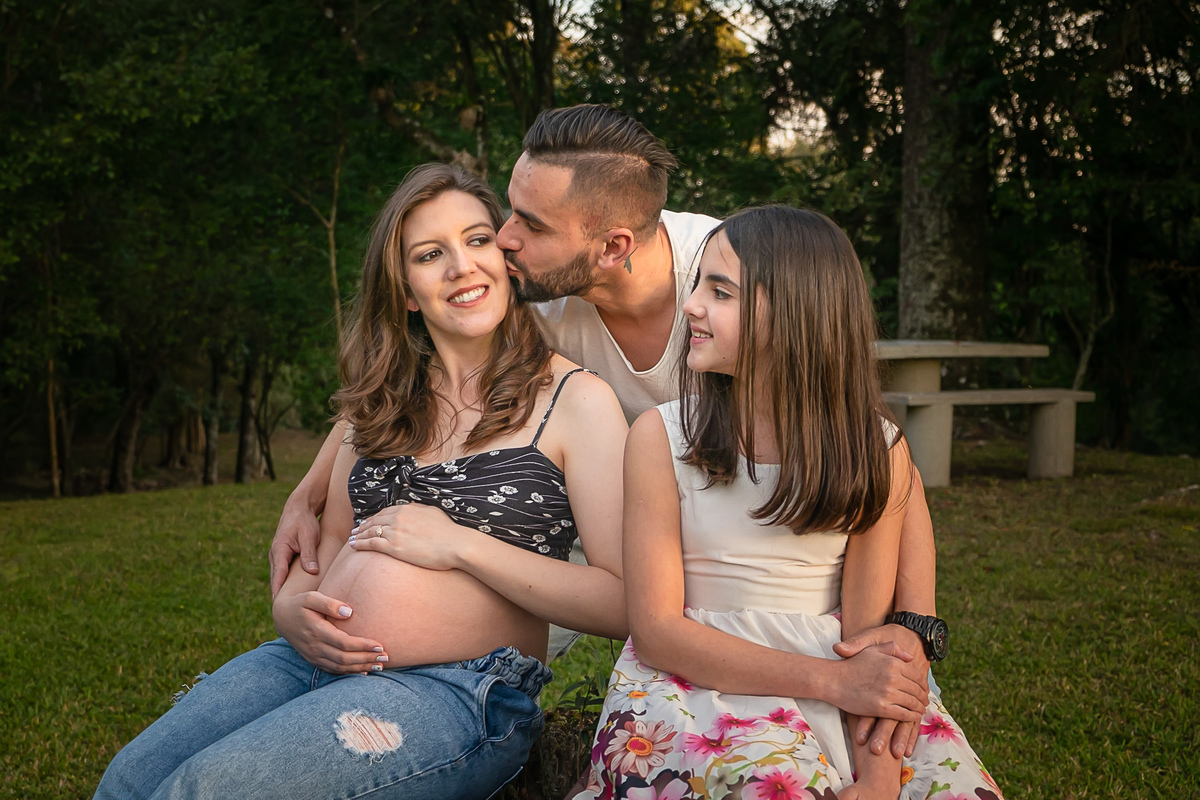 ensaio de gestante- mãe de primeira viagem - ensaio de gesatnte em caxias do sul - fotografo de gestante em caxias do sul  - fotógrafa de gestante - fotos de gestante - suneryfotografia-pai dá um beijo no rosto da mãe -enteada no ensaio de gestante