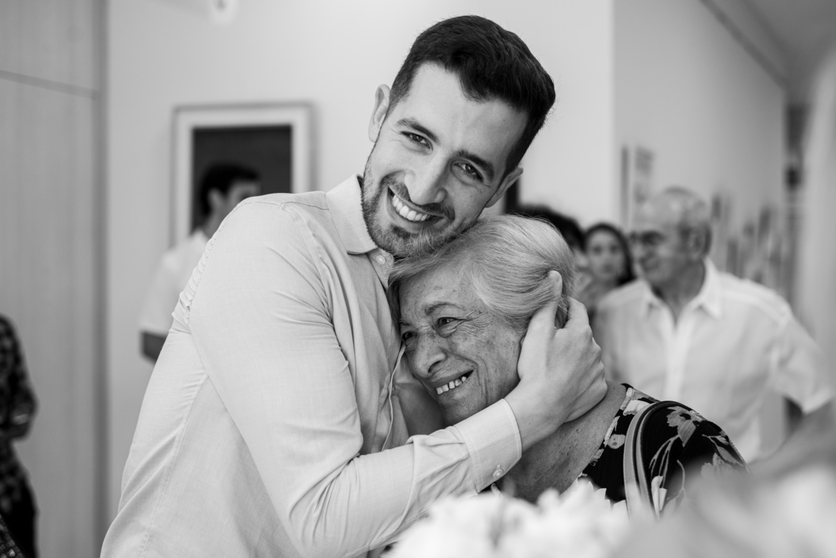 Marcos Pasquare fotógrafo de bodas. El novio abraza a su abuela que esta muy emocionada. Civil de Villa Pueyrredón, CGP N° 12. foto blanco y negro.