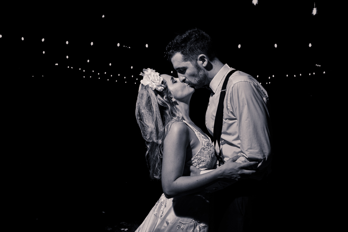 Beso novios final de fiestas con luces de guirnaldas. Foto Blanco y negro. Liceo Naval, Nuñez, CABA.