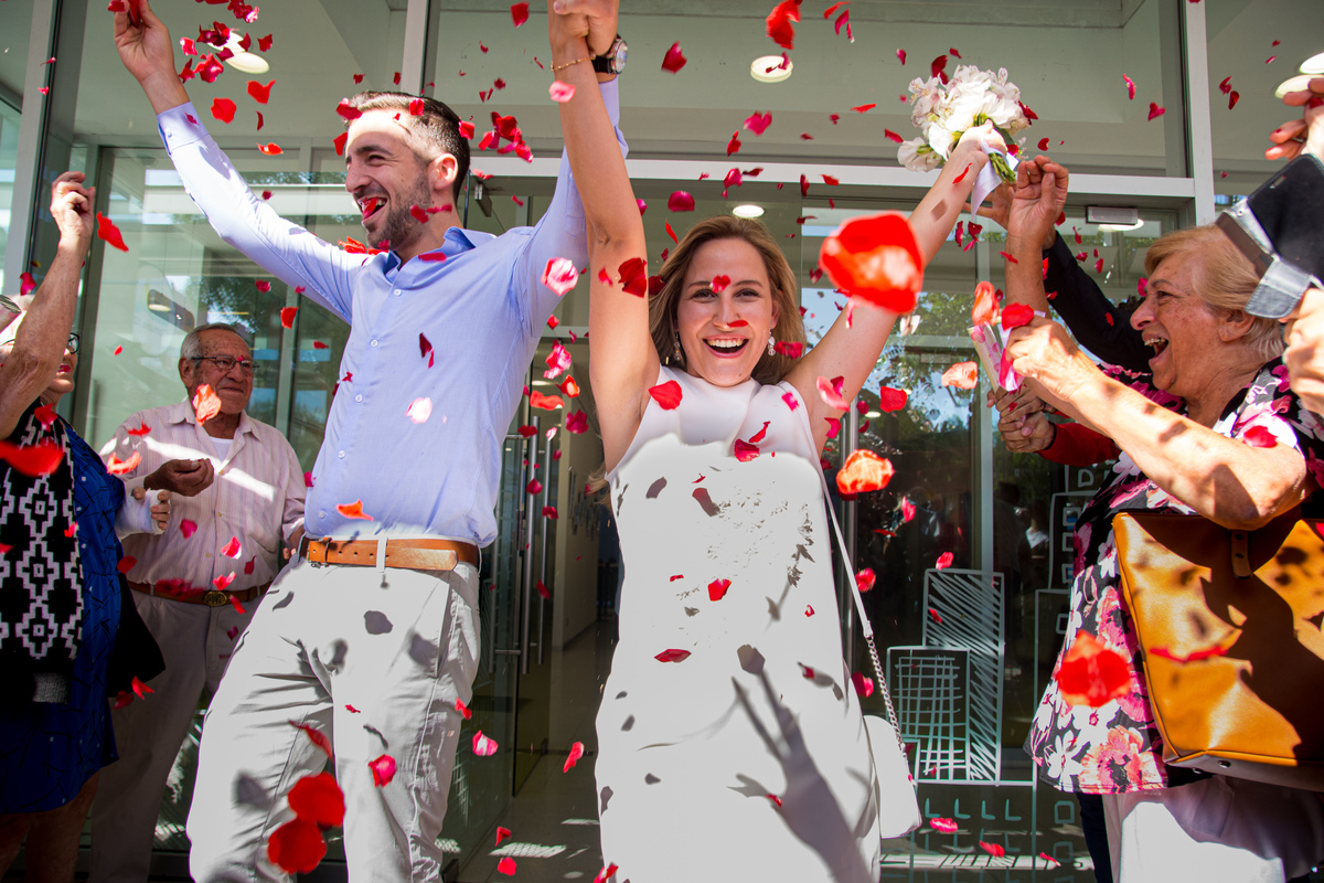 Salida de los novios del registro civil. Vuelan los pétalos de rosas rojas. Marcos Pasquare fotógrafo de bodas
