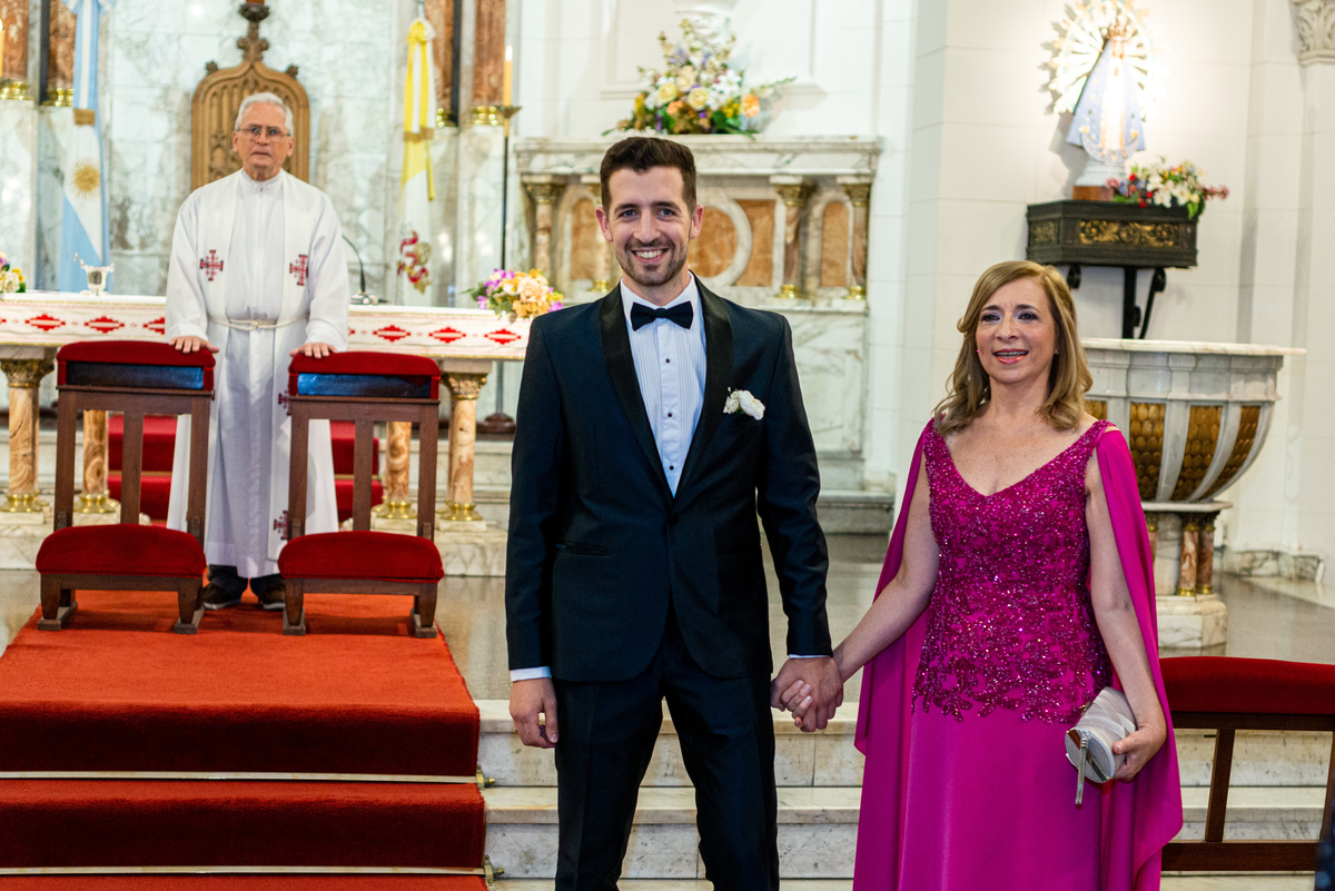 El novio y su madre tomados de la mano en la iglesia Santiago Apóstol. Marcos Pasquare fotógrafo de bodas. Nuñez, Caba.