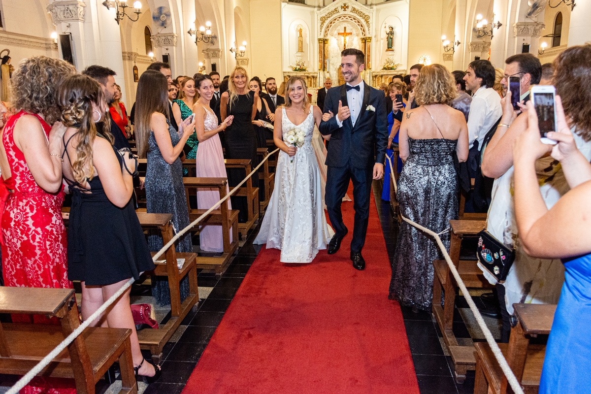 Caminata de los novios hacia la salida de la iglesia Santiago Apóstol. Marcos Pasquare fotógrafo de bodas. Nuñez, Caba.