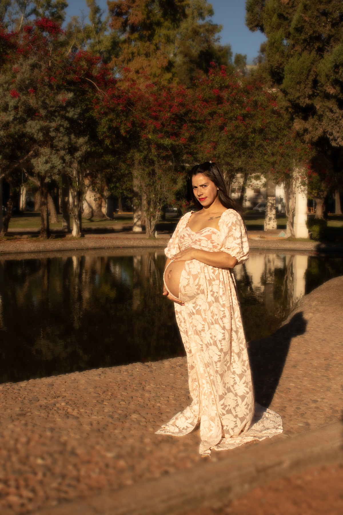 embarazada de perfil, delante de lago artificial, vestido romántico