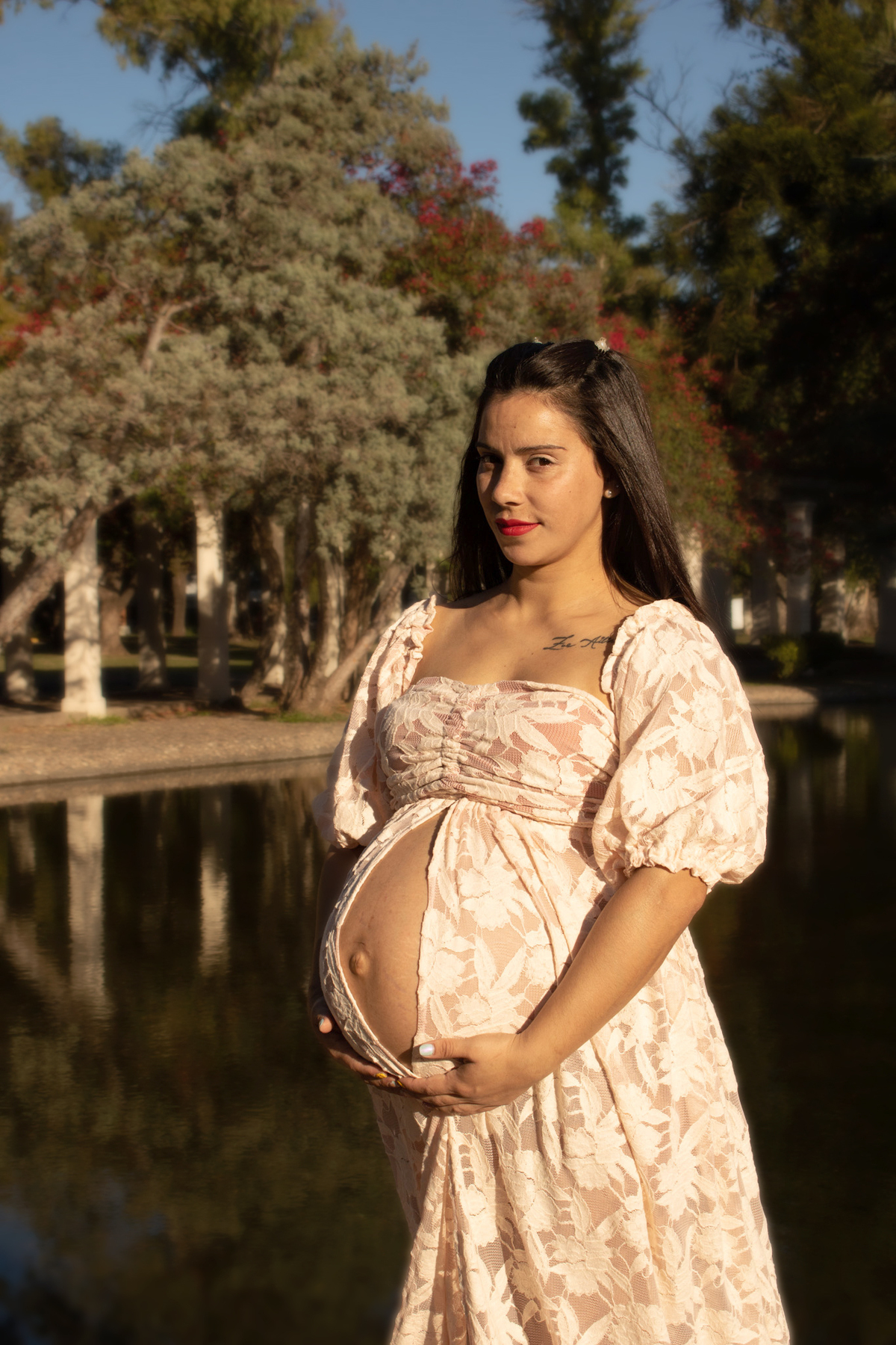 embarazada de perfil, delante de lago artificial, plano medio, vestido romántico