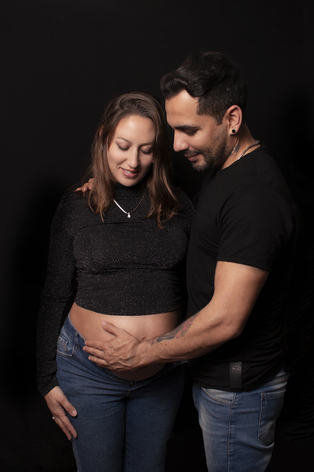 embarazada y su pareja, fondo negro