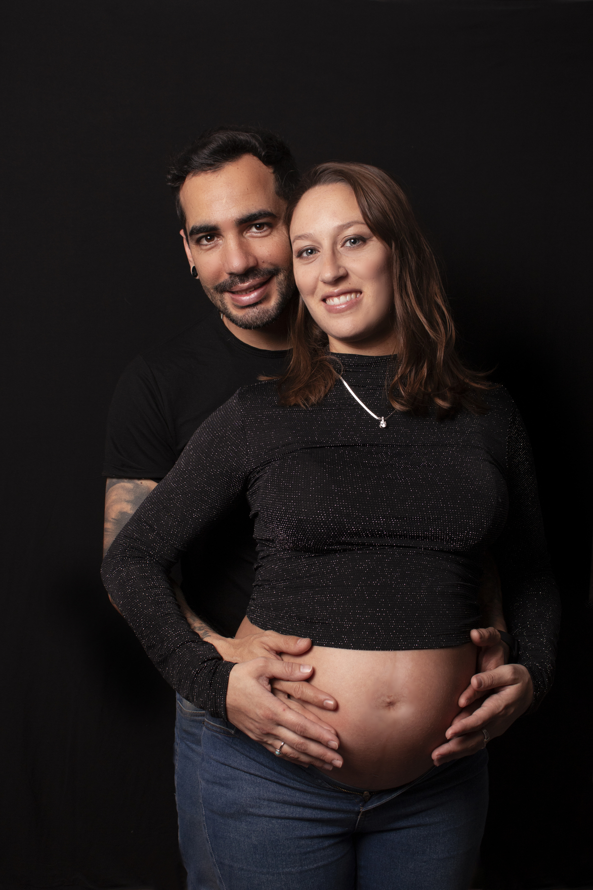 embarazada y su pareja, fondo negro