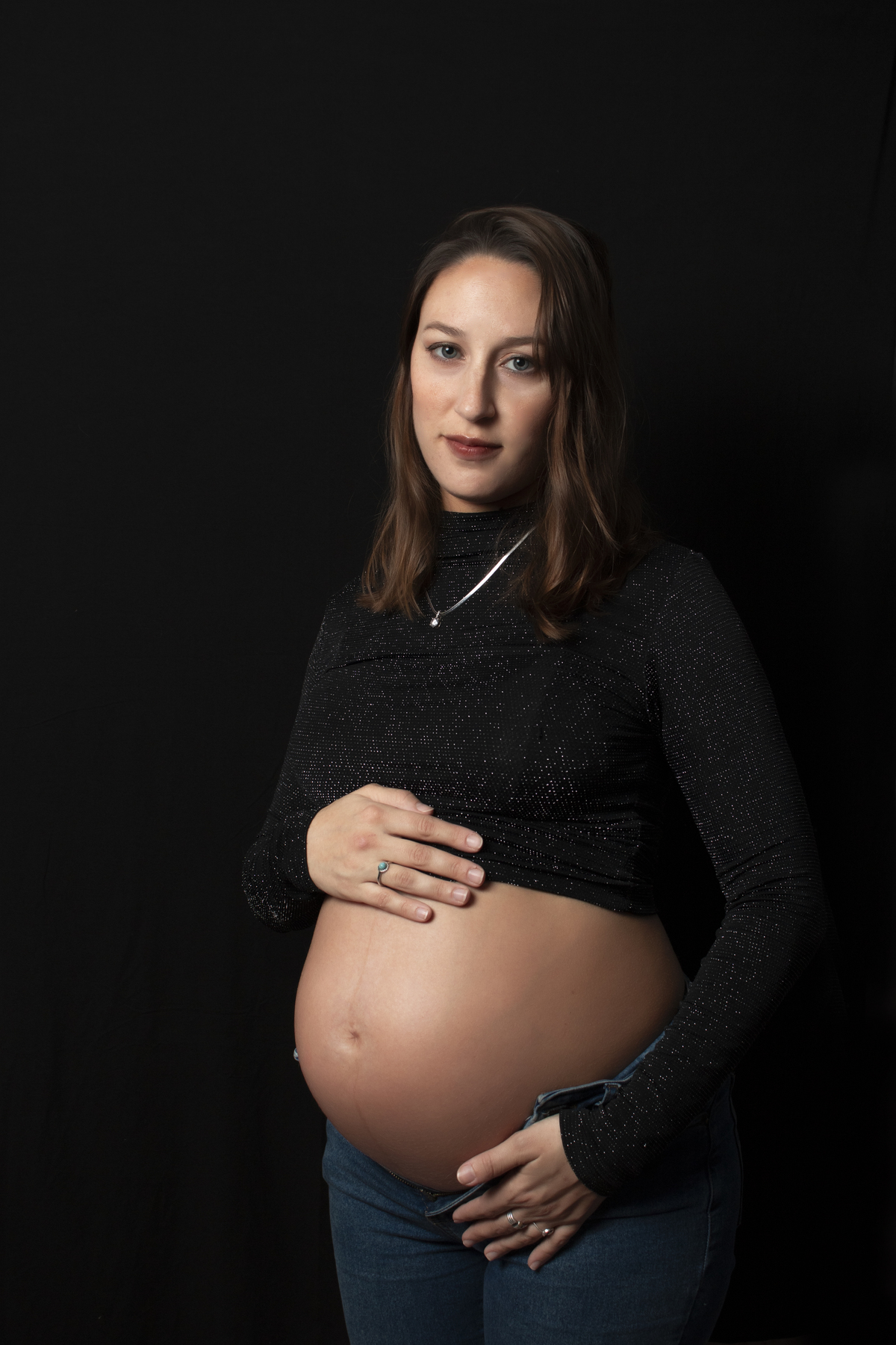 embarazada con ropa casual y fondo negro