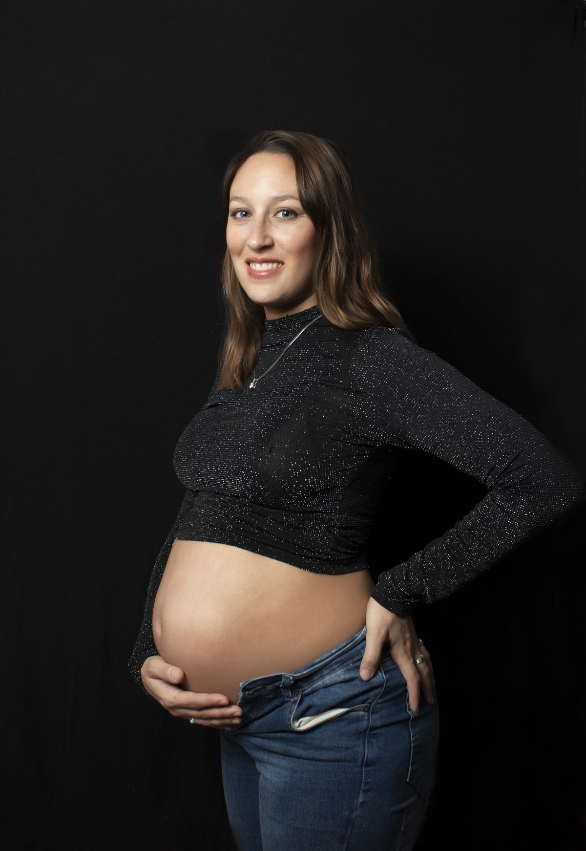 embarazada con ropa casual y fondo negro