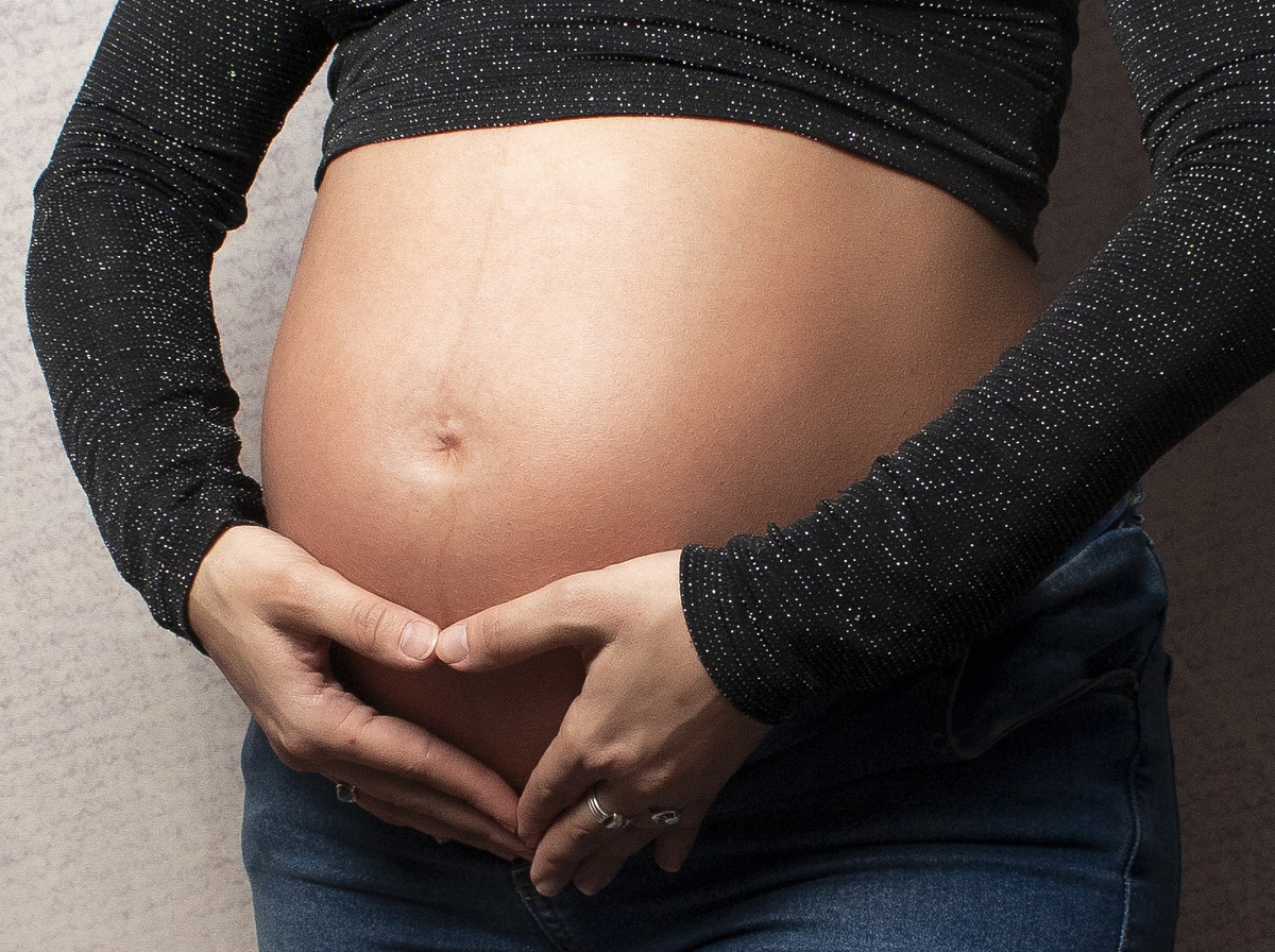 embarazada primerísimo plano con manos de pareja en la panza