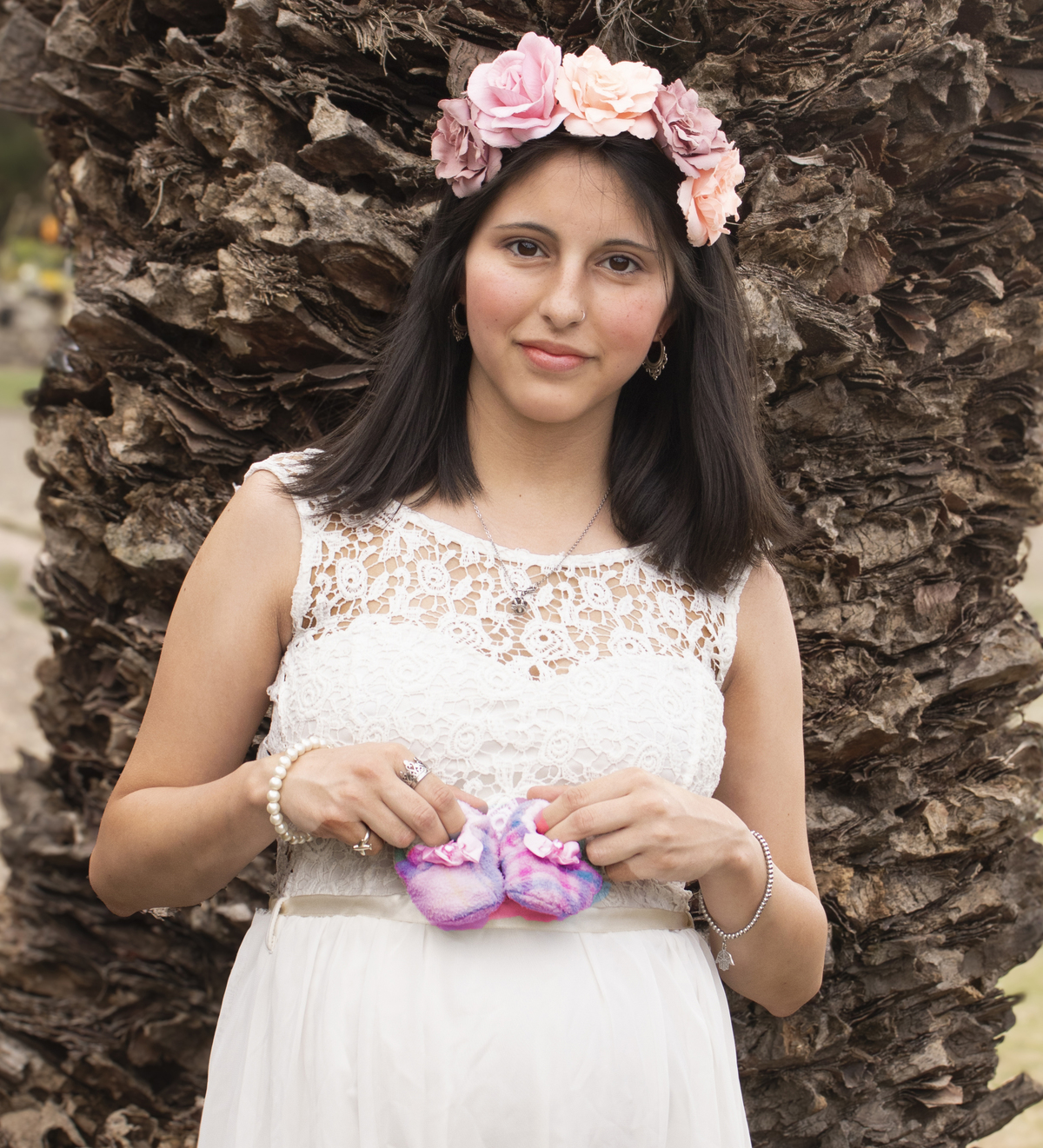 embarazada apoyada en tronco de palmera, plano medio