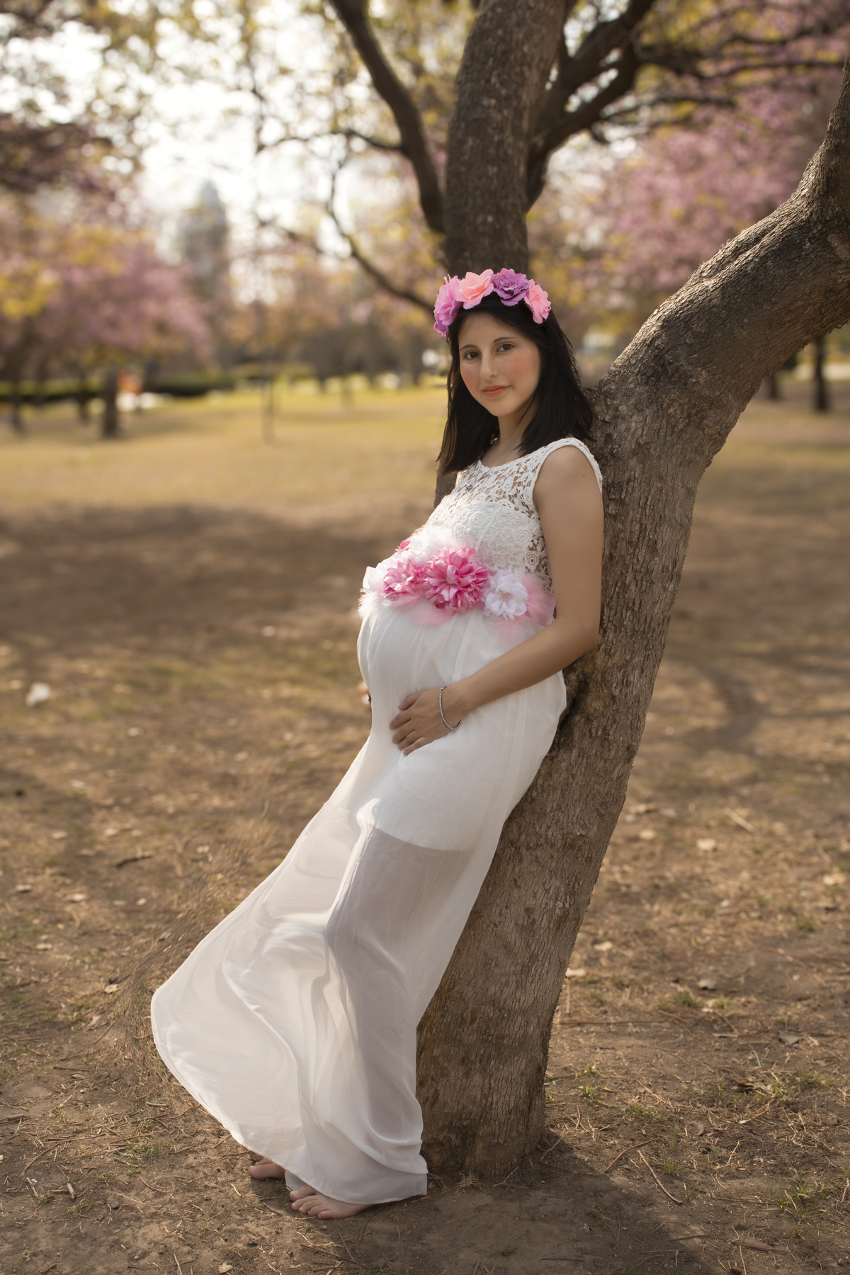 embarazada apoyada en un árbol, plano general