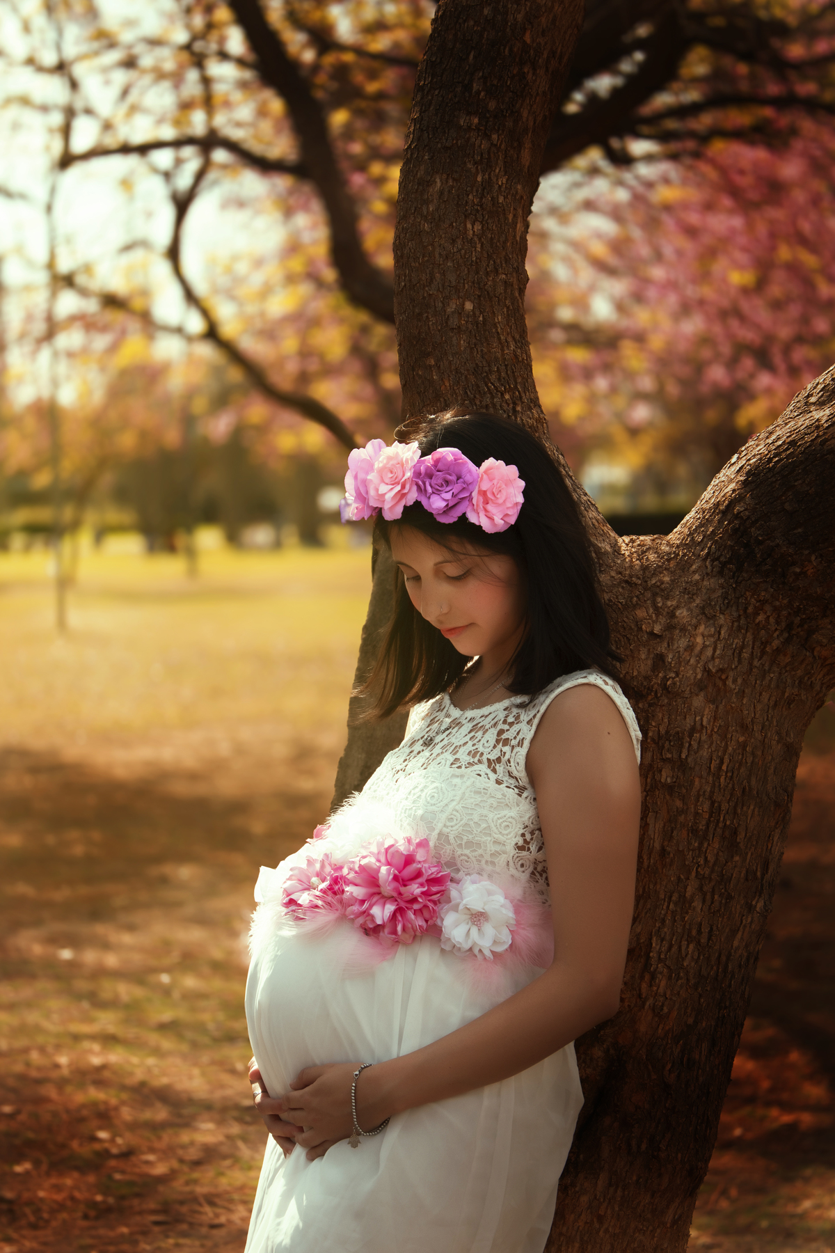 embarazada apoyada en un árbol, plano medio