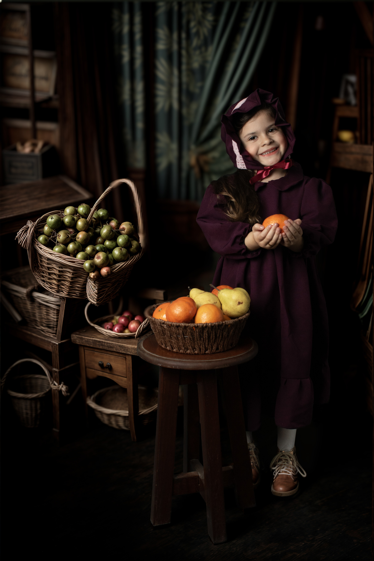 Niña fine art en granero con cestos con frutas