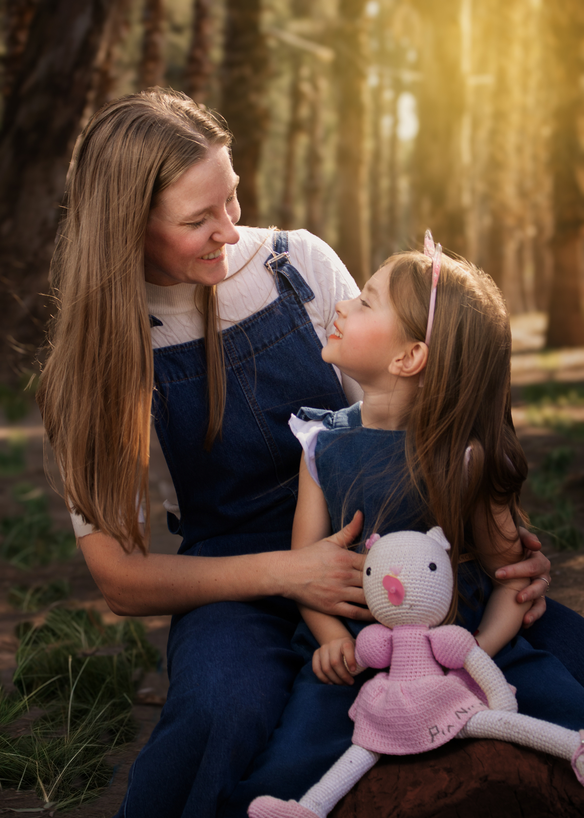 Madre e hija en un bosque mirándose