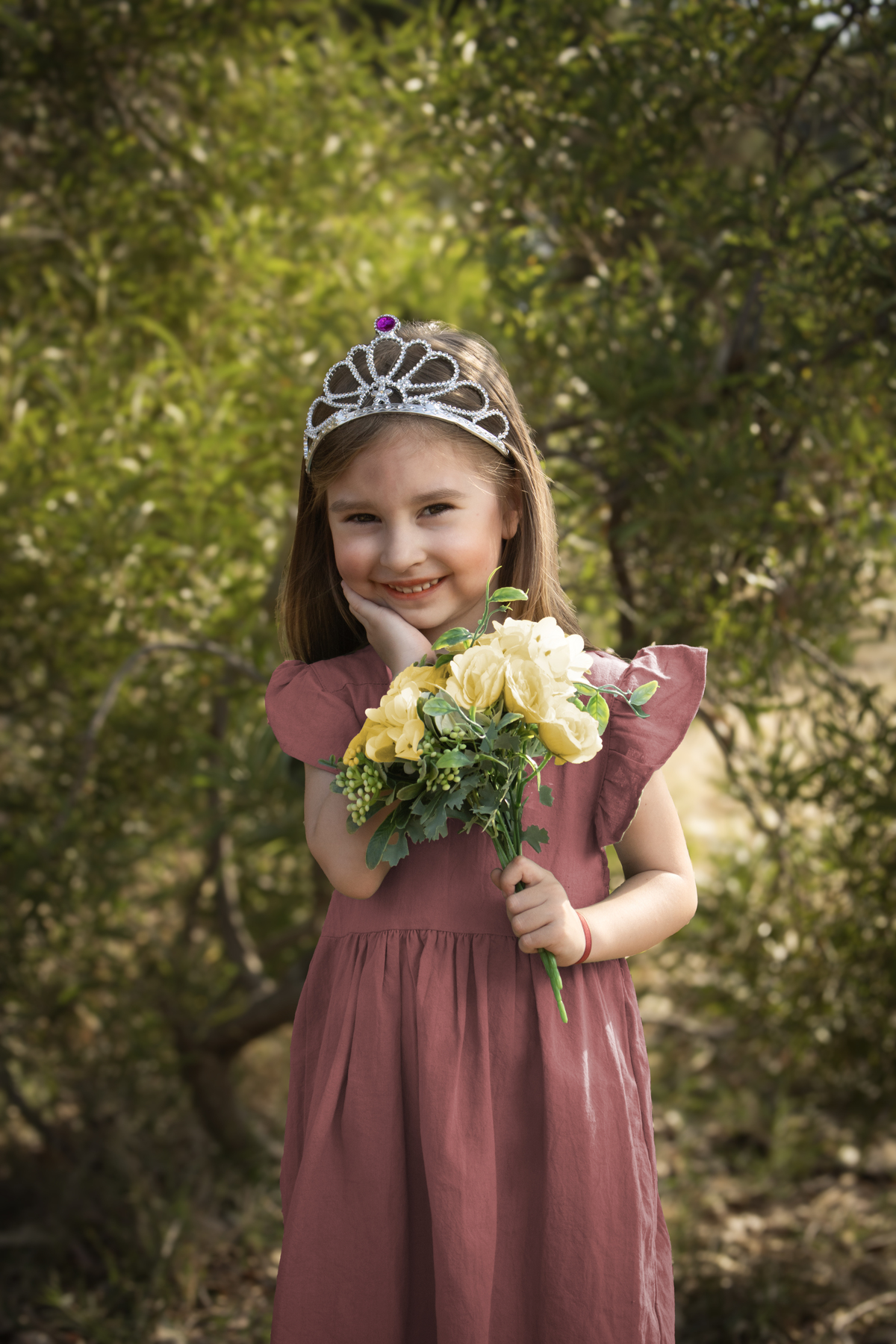 Niña con ramo de flores en el bosque vestido campesino
